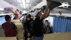Penumpang menaikkan barang bawaan di dalam gerbong Kereta Api Jarak Jauh (KAJJ) di Stasiun Pasar Senen, Jakarta, Rabu (26/3/2025). (Liputan6.com/Herman Zakharia)