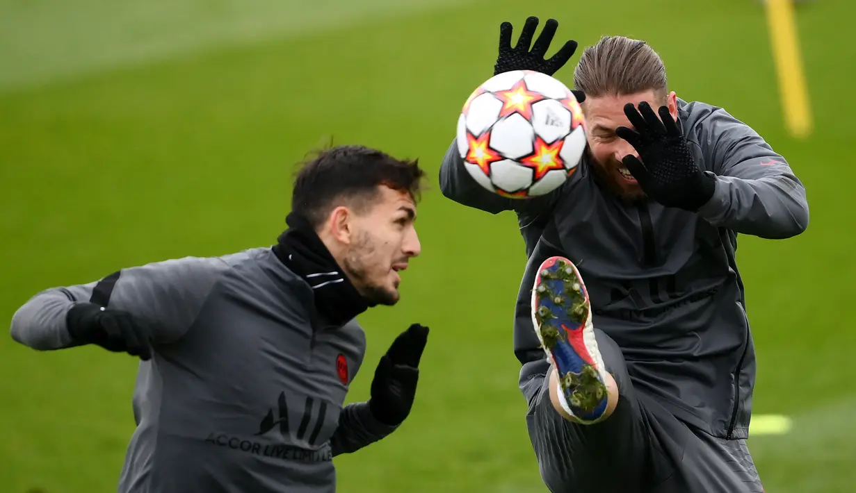 Gelandang PSG Leandro Paredes (kiri) menyundul bola di sebelah Sergio Ramos dalam sesi latihan di tempat latihan klub Camp des Loges di Saint-Germain-en-Laye, Senin (6/12/2021). PSG akan melawan Club Brugge pada matchday terakhir fase grup Liga Champions, Rabu (8/12) dini hari (FRANCK FIFE/AFP)