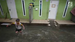 Seorang anak bermain air banjir di kawasan Jatipadang, Jakarta, Rabu (22/11). Jebolnya tanggul Kali Pulo di kawasan tersebut menyebabkan puluhan rumah terendam banjir. (Liputan6.com/Immanuel Antonius)