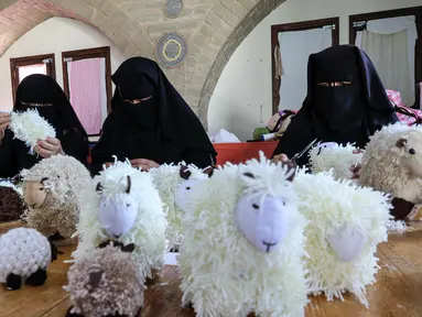 Wanita Palestina membuat boneka domba  menjelang Idul Adha, di desa Badui "Umm Al-Nasr" di Jalur Gaza utara (14/7/2021). Idula Adha merupakan sebuah Hari Raya Islam yang akan di rayakan seluruh umat Islam dunia  pada 20 Juli 2021. (AFP/Mohammed Abed)