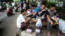 Para pencari suaka bercengkerama di trotoar depan Rumah Detensi Imigrasi Kalideres, Jakarta, Jumat (19/1). Selama 17 minggu, sebanyak 57 WNA tinggal di trotoar karena ruangan Rumah Detensi Imigrasi tersebut penuh. (Liputan6.com/JohanTallo)
