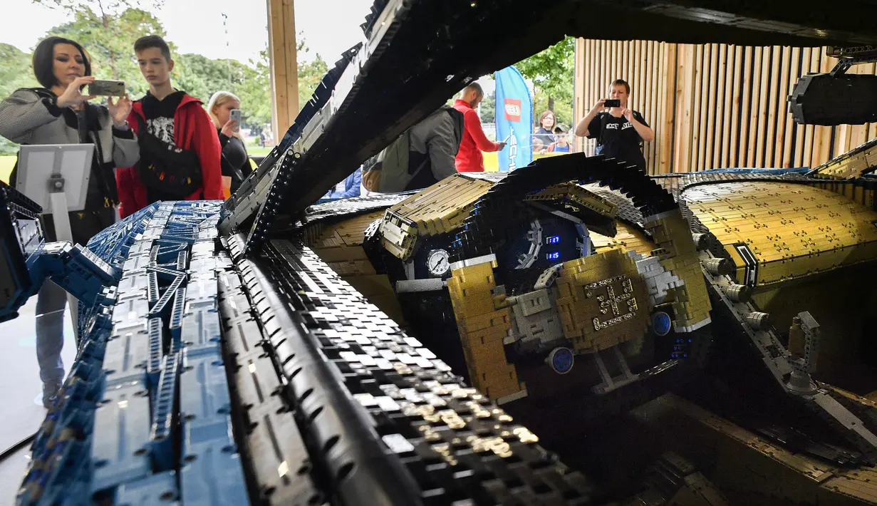 Pengunjung mengamati replika mobil Bugatti Chiron dari jutaan balok Lego Technic pada sebuah pameran di Taman Gorky Moskow, Selasa (23/7/2019). Mobil replika ini bisa dikendarai oleh dua orang dan mampu berakselerasi hingga kecepatan 20 km/jam. (Alexander NEMENOV/AFP)