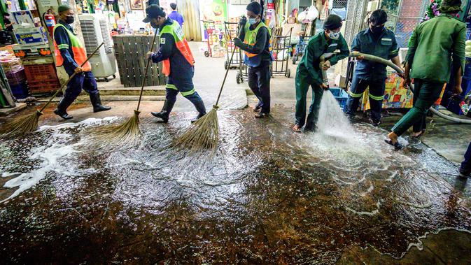 Pekerja Otoritas Metropolitan Bangkok menyapu membersihkan dan mendisinfeksi Pasar Bunga Yodpiman di Bangkok (6/1/2021). Pemerintah memberlakukan pembatasan lebih lanjut karena wabah virus Corona Covid-19 baru-baru ini. (AFP/Mladen Antonov)