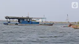 Sebuah kapal terdampar di di kawasan Pulau G Reklamasi, Muara Angke, Jakarta Utara, Kamis (31/10/2019). Bagi nelayan yang sudah biasa berlayar dari dermaga Muara Angke mereka langsung menghindari kawasan Pulau G tersebut. (Liputan6.com/Herman Zakharia)