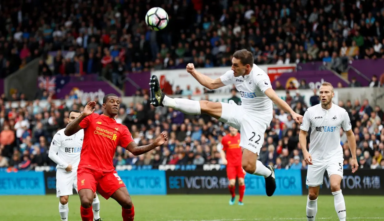 Pemain Swansea City, Angel Rangel, membuang bola saat melawan Liverpool dalam laga Premier League, di Liberty Stadium, Sabtu (1/10/2016). (Reuters/Stefan Wermuth)