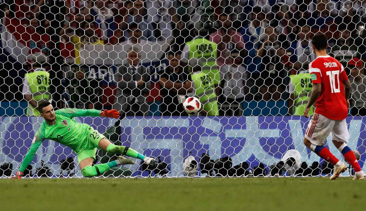 Fedor Smolov. Striker Rusia berusia 32 tahun yang kini bermain bersama Dynamo Moscow ini menjadi pemain kelima yang melakukan eksekusi penalti dengan gaya Panenka di Piala Dunia. Momen itu terjadi saat Rusia kalah melalui adu penalti 3-4 (1-1) dari Kroasia pada babak perempatfinal Piala Dunia 2018 (7/7/2018) di Rusia. Sebagai penendang pertama, eksekusi penalti Panenka-nya gagal karena mampu dibaca kiper Kroasia, Danijel Subasic. (AFP/Adrian Dennis)