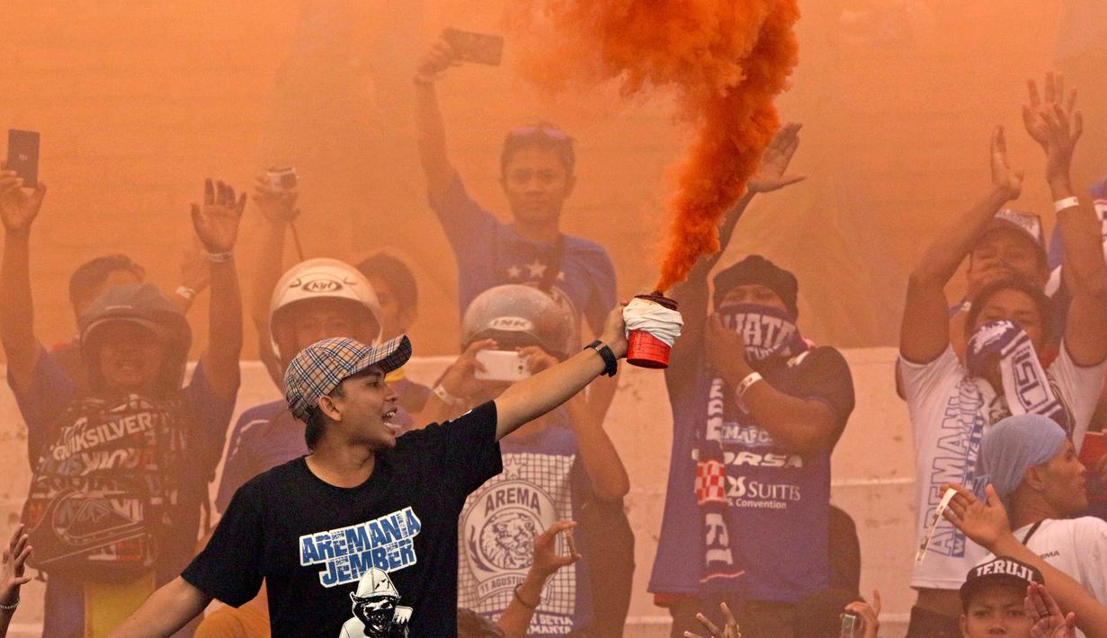 Aksi Aremania menyalakan suar saat laga Bali Island Cup 2016 melawan PSS Sleman di Stadion Kapten I Wayan Dipta, Bali, Minggu (21/2/2016). (Bola.com/Peksi Cahyo)