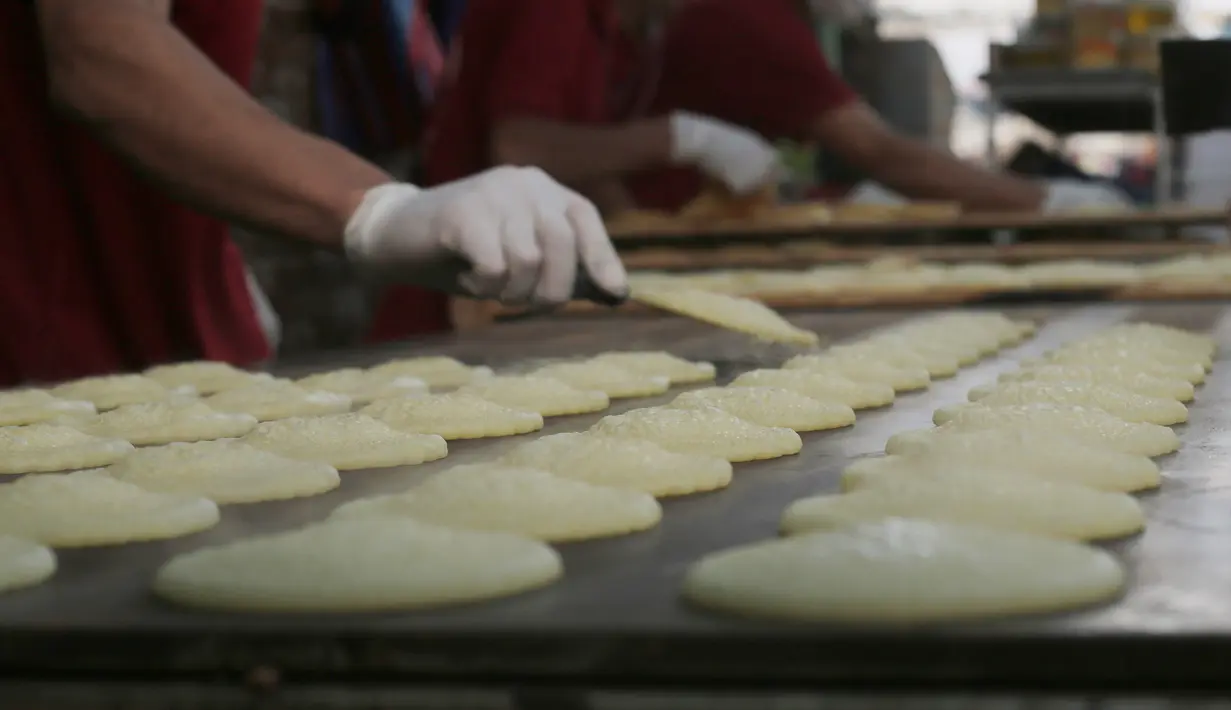 Warga membuat penganan manis tradisional yang dikenal dengan nama Qatayef di Kota Rafah, Jalur Gaza, Palestina, Senin (27/4/2020). Qatayef dapat diisi dengan krim atau kacang. (Xinhua/Khaled Omar)