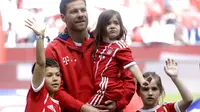 Gelandang Bayern Muenchen, Xabi Alonso, berpose bersama ketiga anaknya sebelum melakoni laga terakhir di sepak bola. Alonso dan Philipp Lahm gantung sepatu usai laga melawan Freiburg, Sabtu (20/5/2017). (AP Photo/Matthias Schrader)