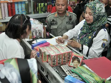 Petugas BPOM (Balai Pengawas Obat dan Makanan) bersama Polres Jakarta Pusat, Dinas Kesehatan dan Satpol PP memeriksa kosmetik saat melakukan razia di pertokoan Pasar Baru, Jakarta, Rabu (12/12). (Merdeka.com/Iqbal S. Nugroho)