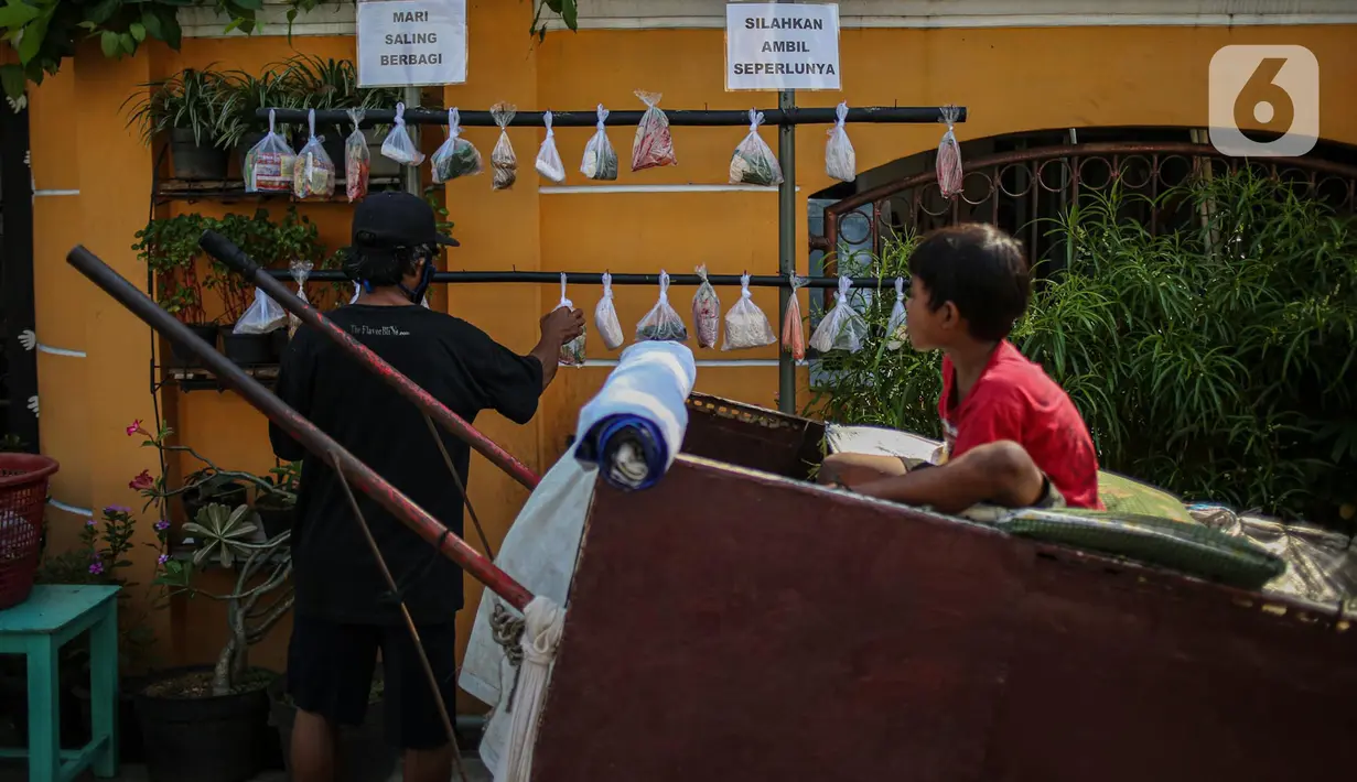 Warga memilih sayur mayur hasil sumbangan di RT 02 RW 04, Kelurahan Jati Padang, Jakarta, Jumat (22/5/2020). Pakaian bekas layak pakai serta sayur mayur disediakan bagi warga terdampak Pembatasan Sosial Berskala Besar (PSBB) untuk pencegahan COVID-19. (Liputan6.com/Faizal Fanani)
