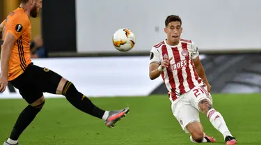 Bek Olympiakos, Kostas Tsimikas (kanan) mengumpan bola saat bertanding melawan Wolves pada leg kedua babak 16 besar Liga Europa di Molineux Stadium, Wolverhampton, Inggris, (6/8/2020). Tsimikas resmi direkrut Liverpool dengan biaya mencapai 11,7 juta pound sterling. (AP Photo/Rui Vieira)