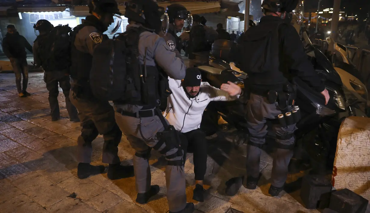 Polisi anti huru hara Israel menahan seorang pria Palestina selama bentrokan di dekat Gerbang Damaskus di luar Kota Tua Yerusalem, Kamis (22/4/2021).  Bentrokan terjadi menjelang pawai yang direncanakan oleh Lahava, sebuah kelompok ekstremis Yahudi. (AP Photo/Mahmoud Illean)