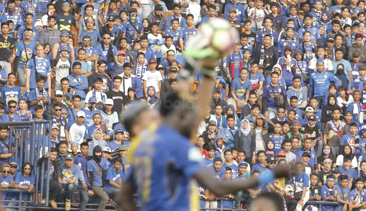 Suporter melihat duel udara antara striker Persib, Ezechiel N'Douassel, dengan kiper Semen Padang Muhammad Ridwan, di Stadion Si Jalak Harupat, Bandung, Sabtu, (9/9/2017). Persib ditahan imbang 2-2 oleh Semen Padang. (Bola.com/M Iqbal Ichsan)