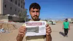 Seorang pria Palestina menunjukkan salah satu selebaran yang disebarkan oleh tentara Israel di Beit Hanun, Jalur Gaza utara pada 19 Maret 2025. (BASHAR TALEB/AFP)