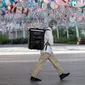 Seorang delivery man yang mengenakan jaring rambut dan masker berjalan di Bangkok, Thailand pada Senin (4/1/2021). Pejabat kesehatan di Thailand pada Senin mencatat 745 kasus virus corona baru, rekor tertinggi harian di negara itu sejak dimulainya  pandemi COVID-19. (Jack TAYLOR / AFP)