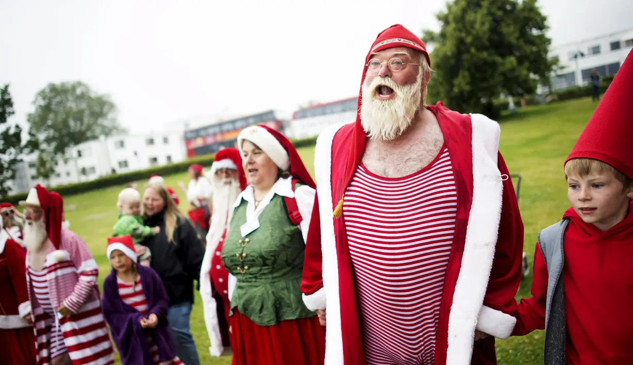 Sejumlah peserta Kongres Santa Claus Dunia 2015 berkumpul untuk bersiap berenang di pantai Bellevue di Copenhagen, Denmark, Minggu (21/7/2015). (REUTERS/Scanpix Denmark/Erik Refner)