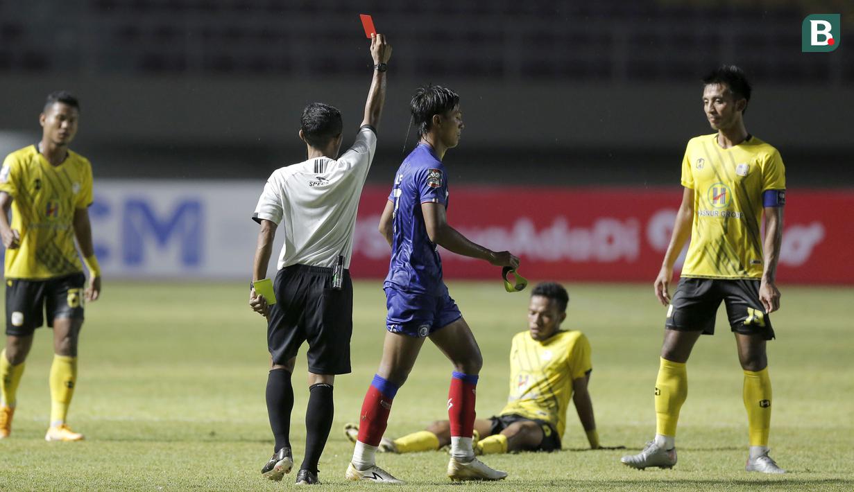 Bek Arema FC, Johan Ahmat Farizi (tengah) mendapat kartu merah dari wasit Mochammad Adung saat menghadapi Barito Putera dalam laga matchday ke-2 Grup A Piala Menpora 2021 di Stadion Manahan, Solo, Kamis (25/3/2021). Arema FC kalah 1-2 dari Barito Putera. (Bola.com/Arief Bagus)