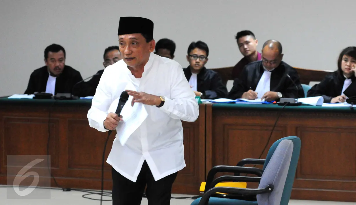 Mantan Bupati Bangkalan Fuad Amin mengecek mikrofon sebelum sidang pemeriksaan terdakwa di Pengadilan Tipikor, Kamis (17/9). Fuad mengaku menerima uang suap dari PT Media Karya Sentosa terkait proyek eksplorasi gas. (Liputan6.com/Helmi Afandi)