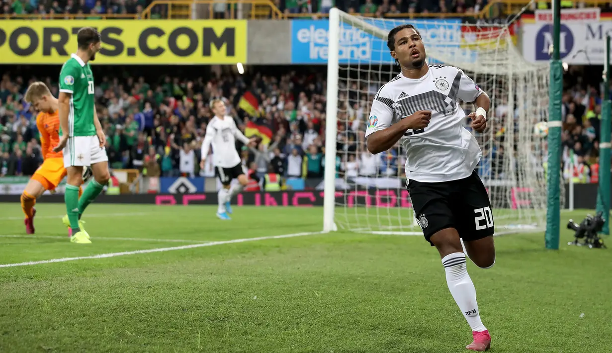 Gelandang Jerman, Serge Gnabry melakukan selebrasi usai mencetak gol ke gawang Irlandia Utara dalam kualifikasi Euro 2020 di Windsor Park, Belfast, Senin (9/9/2019). Jerman berhasil merebut puncak klasemen grup C kualifikasi Euro 2020 usai mengalahkan Irlandia Utara 2-0. (Paul Faith/AFP)