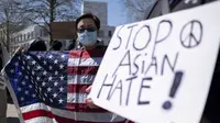 Lucy Lee memegang bendera Amerika saat unjuk rasa "Stop Asian Hate" di luar Gedung Kongres Georgia di Atlanta, Sabtu (20/3/2021). Ratusan demonstran berkumpul mendukung komunitas Asia-Amerika setelah penembakan di tiga tempat spa yang menewaskan 8 orang, termasuk 6 wanita Asia. (AP Photo/Ben Gray)