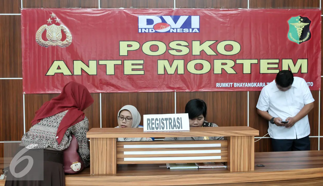 Petugas membantu keluarga untuk pelengkapan data serta postmortem korban KM Zahro di RS Polri, Jakarta, Selasa (3/1). Seperti DNA, foto dengan melihatkan gigi dan rekam jejak kesehatan. (Liputan6.com/Yoppy Renato)