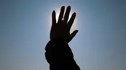 Wisatawan menerima energi matahari selama upacara menyambut fenomena equinox di depan Piramida Matahari, Teotihuacan, Meksiko, Senin (20/3). Fenomena equinox merupakan peristiwa ketika matahari tepat berada di atas khatulistiwa. (AP/Rebecca Blackwell)