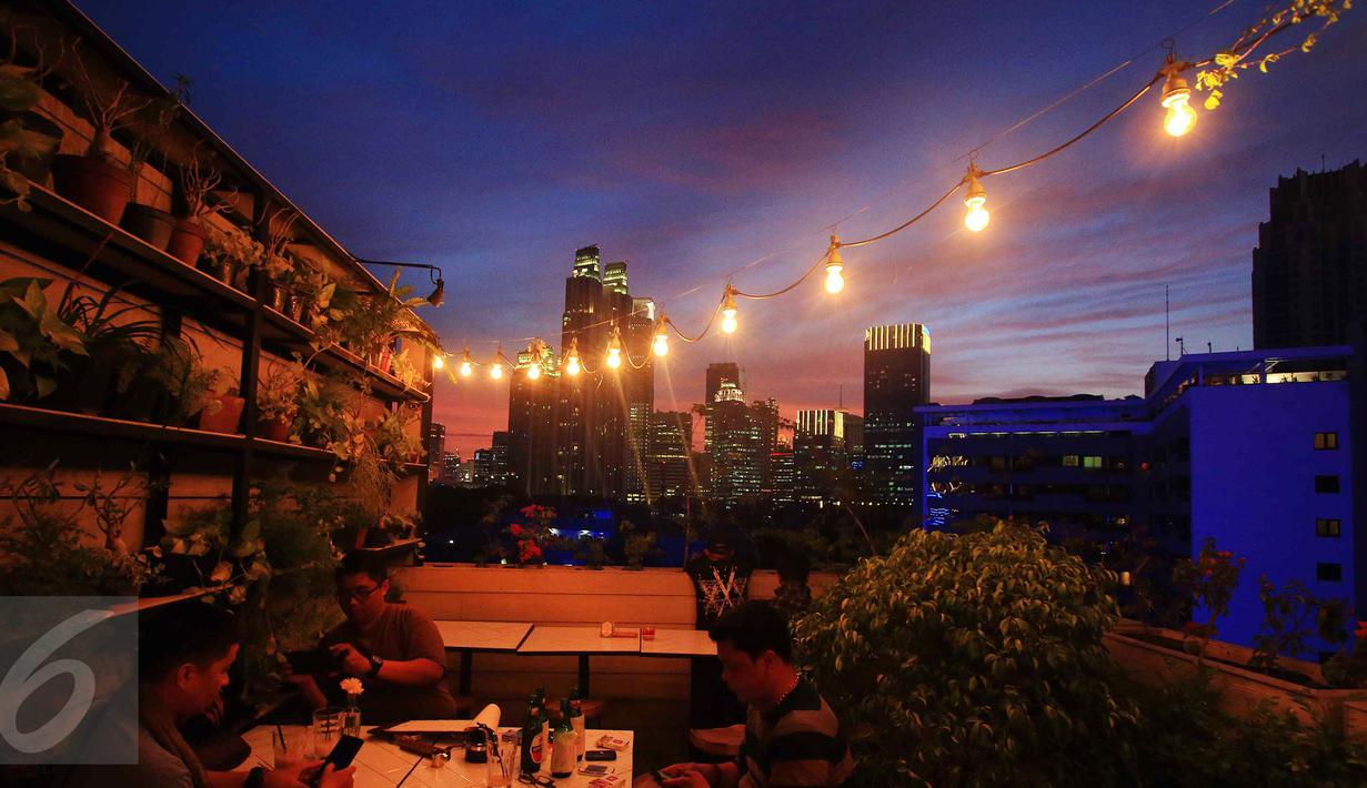 Sejumlah warga menikmati pemandangan saat senja di Jakarta, Rabu (23/12/2015). Langit Jakarta membiaskan cahaya matahari diantara gumpalan awan menjadikannya pemandangan yang sangat indah. (Liputan6.com/Angga Yuniar)