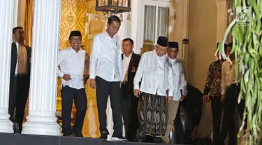 Pasangan capres-cawapres nomor urut 01 Joko Widodo (kiri) dan Ma'ruf Amin menghampiri wartawan di kediaman Ma'ruf Amin, Jalan Situbondo, Menteng, Jakarta, Kamis (27/6/2019). Jokowi menjemput Ma'ruf untuk nonton bareng sidang putusan MK di Lanud Halim Perdanakusuma. (Liputan6.com/Herman Zakharia)