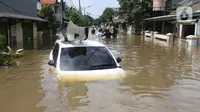 Kondisi mobil yang terseret arus banjir di perumah Ciledug Indah, Tangerang, Banten, Kamis (2/1/2020). (Liputan6.com/Angga Yuniar).