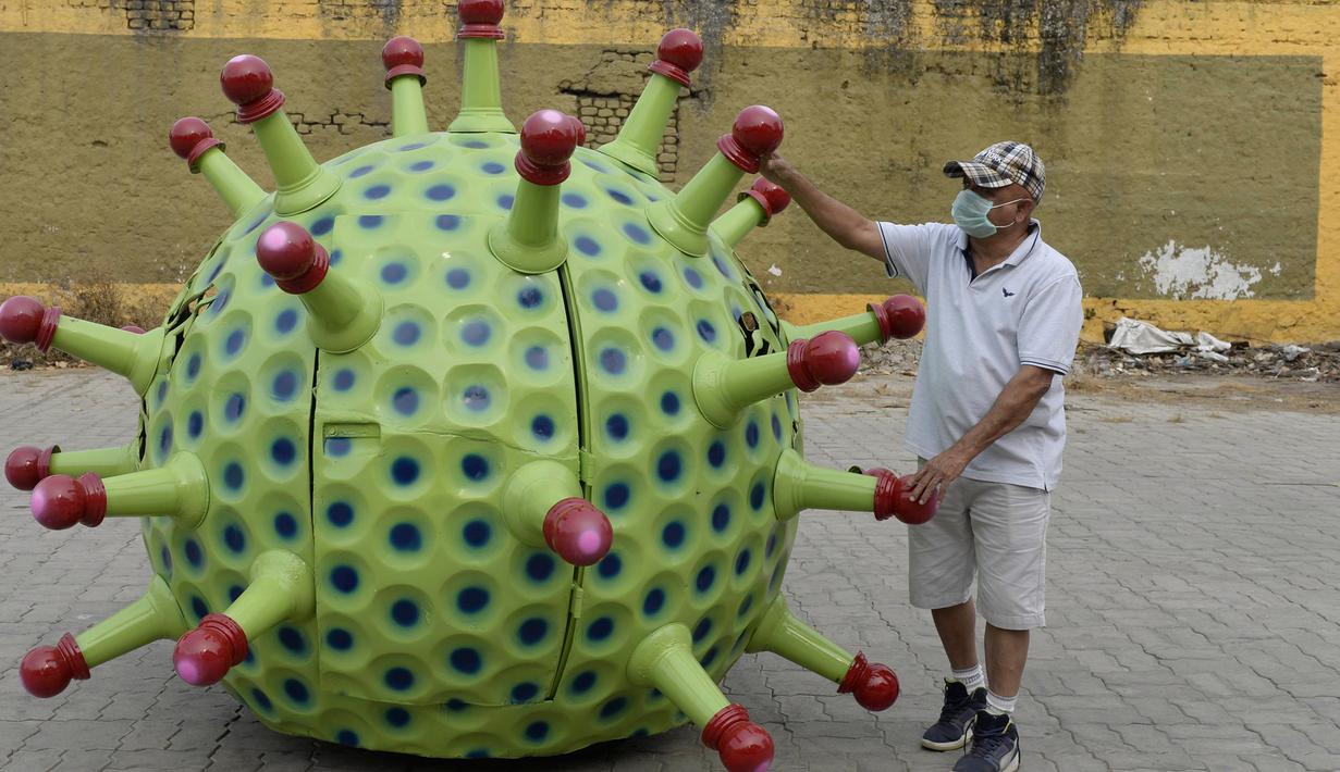 Desainer mobil India K. Sudhakar Yadav berdiri di samping mobil bertema Coronavirus di museum di Hyderabad, India, Selasa (7/4/2020). Mobil bertema Coronavirus ini Sudhakar Yadav sendiri yang membuatnya sebagai bagian dari kampanye kesadaran mencegah penyebaran virus tersebut. (AFP/Noah Seelam)