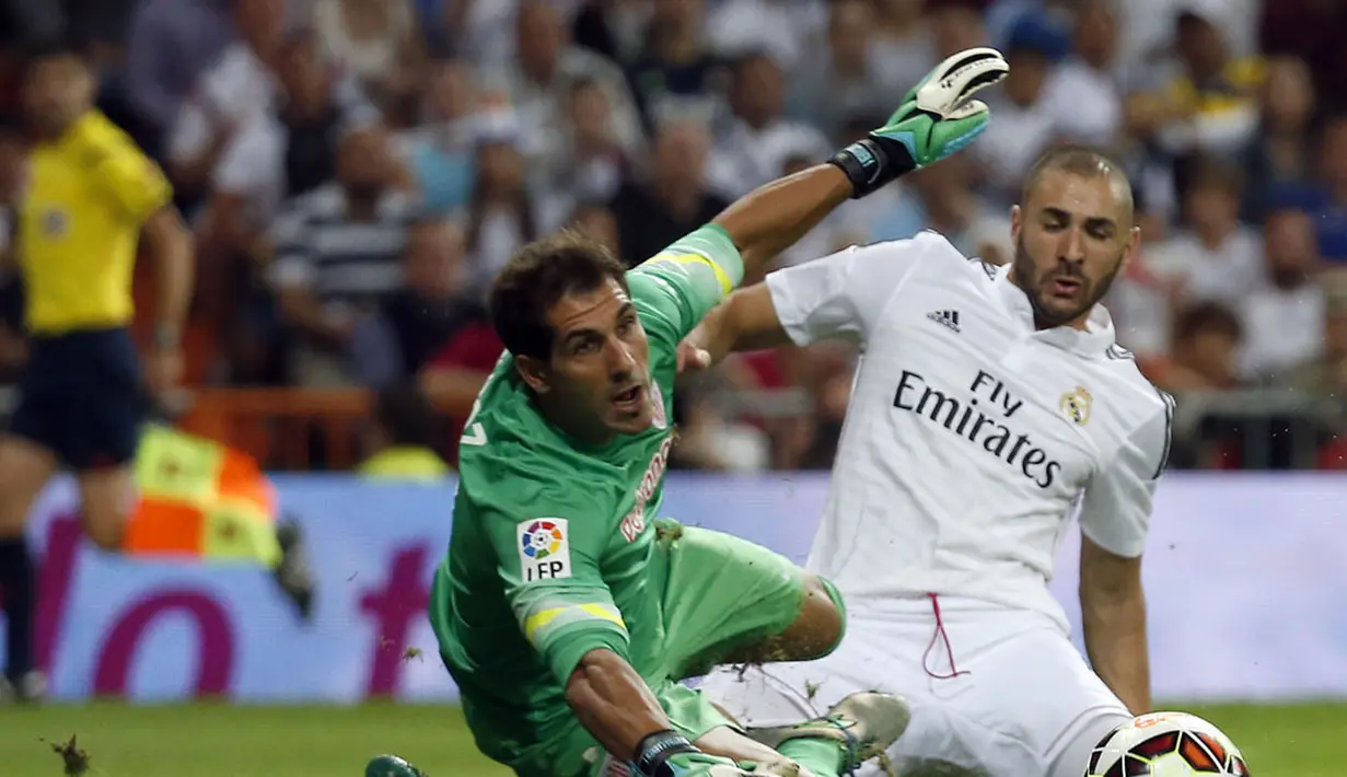Penyerang Real Madrid, Karim Benzema berusaha mengecoh penjaga gawang Athletic Bilbao, Gorka Iraizoz di lanjutan La Liga Spanyol di Stadion Santiago Bernabeu, (6/10/2014). Real Madrid unggul telak 5-0 atas Athletic Bilbao. (REUTERS/Sergio Perez)