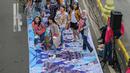 Sejumlah orang yang mengenakan batik berpose di catwalk Jalan Jenderal Sudirman, Jakarta, Minggu (2/10/2022). Kegiatan yang diikuti ratusan orang ini diselenggarakan oleh Bank Mandiri untuk menyambut Hari Batik Nasional yang jatuh setiap tanggal 2 Oktober 2022. (Liputan6.com/Faizal Fanani)