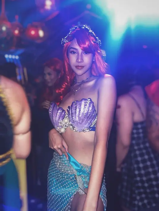 Anya Geraldine mengenakan bra berwarna ungu yang terlihat seperti cangkang mutiara dipadukan dengan rok berwarna tosca yang memiliki potongan belahan tinggi hingga pangkal paha saat menjadi Ariel si mermaid. (Instagram/anyageraldine)