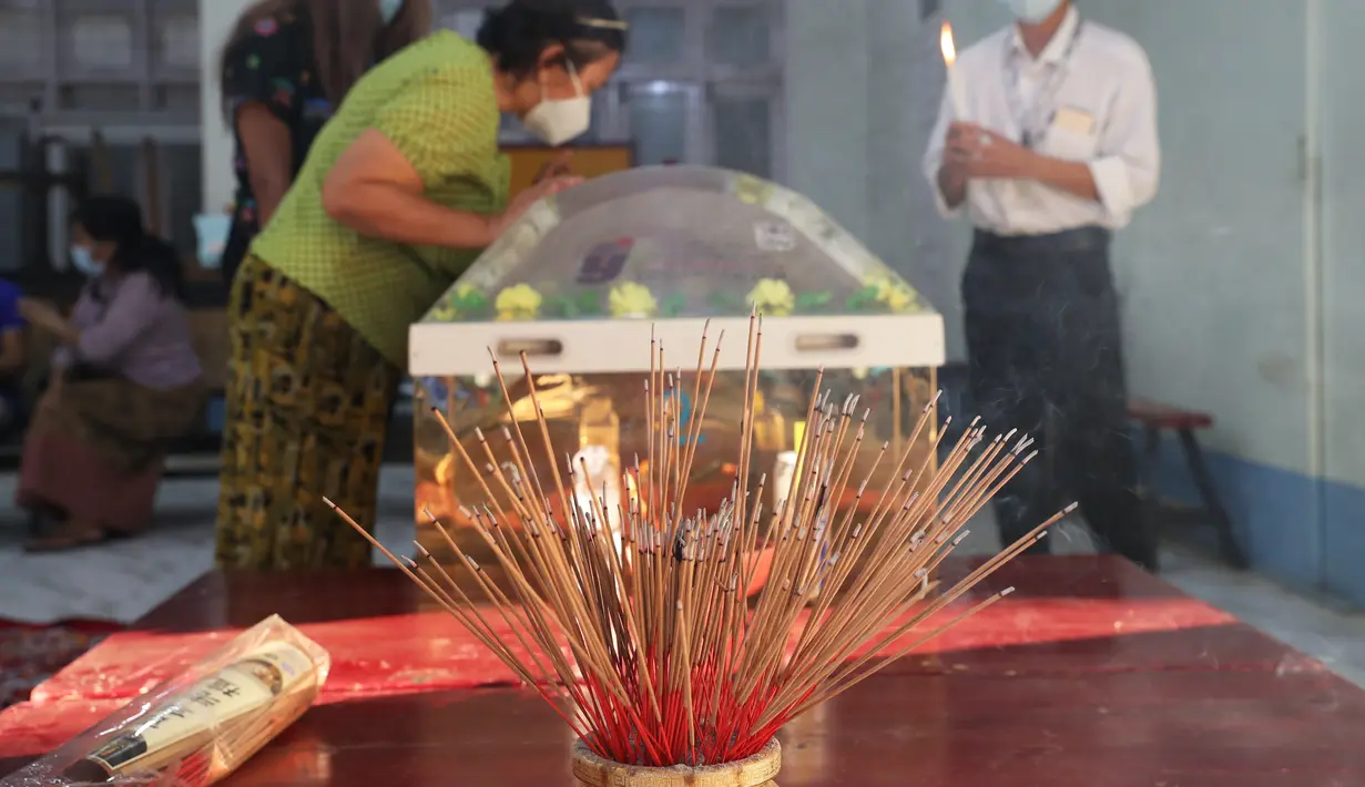 Dupa dinyalakan di kuil Tionghoa Yunnan saat orang-orang melihat tubuh Kyal Sin atau akrab disapa Angel, yang tewas dalam demonstrasi menentang kudeta militer, di Mandalay, Myanmar, Rabu (3/3/2021). Mahasiswa 19 tahun tersebut kepalanya ditembak oleh petugas militer Myanmar. (AP Photo)