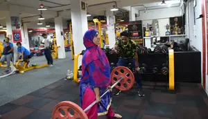 Seorang wanita Muslim India mengangkat beban saat berlatih di gym Ahmedabad Fitness Academy (AFA) di Ahmedabad (10/5/2019). Selama bulan suci Ramadhan, tempat gym ini tetap buka hingga larut malam untuk membiarkan anggota Muslim berolahraga setelah salat. (AFP Photo/Sam Panthaky)