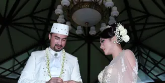Reza Pahlevi menyematkan cincin ke jari Astrilika Lintong setelah resmi menjadi pasangan suami istri pada sore menjelang senja (28/8/2015). (Deki Prayoga/Bintang.com)