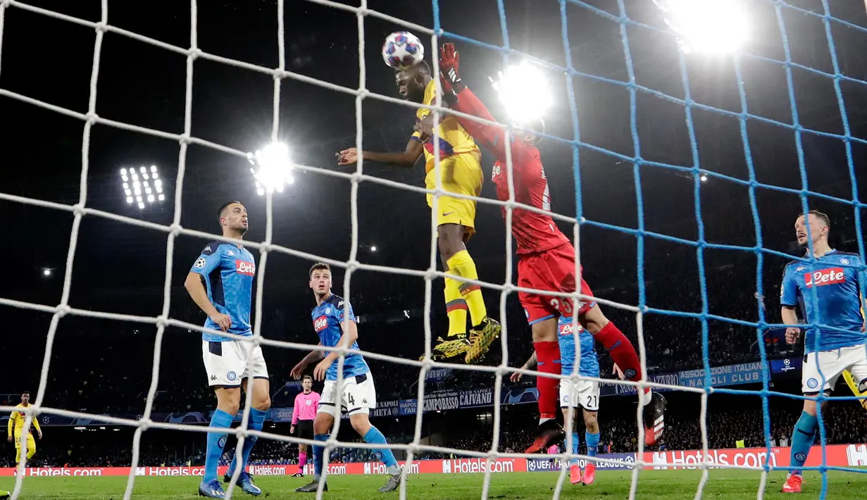 Kiper Napoli David Ospina (kanan) melakukan penyelamatan saat pemain Barcelona Samuel Umtiti mencoba mencetak gol pada pertandingan babak 16 besar Liga Champions di San Paolo Stadium, Naples, Italia, Selasa (25/2/2020). Pertandingan berakhir dengan skor 1-1. (Alfredo Falcone/Andrew Medichini)