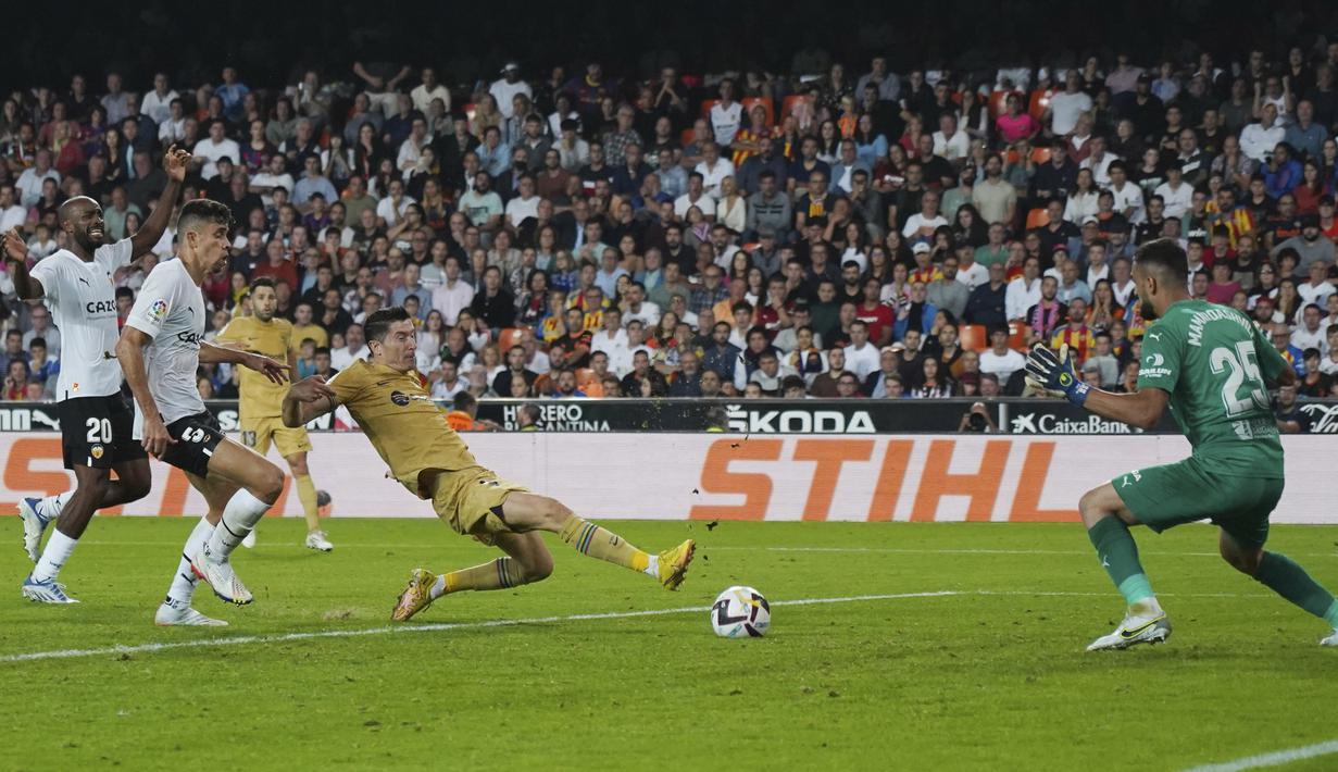Robert Lewandowski akhirnya mampu menjebol gawang Valencia yang dijaga Giorgi Mamardashvili di menit 90+3. Gol ini berbuah tiga poin untuk Blaugrana. (AP Photo/Alberto Saiz)