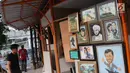 Seniman lukis memasang lukisan pada dinding yang berada di Sentra Lukisan Pasar Baru, Jakarta, Jumat (16/11). Sejumlah seniman lukis mengeluhkan kondisi lapak Sentra Lukisan Pasar Baru. (Liputan6.com/Immanuel Antonius)