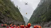 Sebuah drone membawa muatan melintasi udara saat operasi pencarian dan penyelamatan berlangsung di wilayah yang dilanda tanah longsor di Kabupaten Gyirong, Daerah Otonom Tibet, Tiongkok barat daya, Sabtu, 29 Agustus 2026. (Jiang Fan/Xinhua via AP)