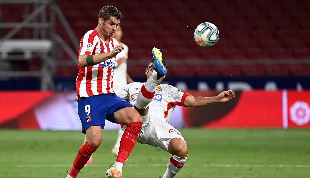 Penyerang Atletico Madrid, Alvaro Morata, berebut bola dengan bek Real Mallorca, Aleksandar Sedlar, pada laga lanjutan La Liga di Wanda Metropolitano, Sabtu (4/7/2020) dini hari WIB. Atletico Madrid menang 3-0 atas Mallorca. (AFP/Pierre-Philippe Marcou)