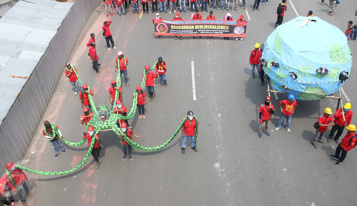 Massa Konfederasi Kongres Aliansi Serikat Buruh Indonesia (KASBI) pada peringatan May Day di Bundaran HI, Jakarta, Senin (1/5). Mereka akan melakukan aksi ke Istana Merdeka dengan membawa gurita raksasa, bola dunia dan tikus. (Liputan6.com/Angga Yuniar)
