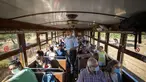 Inspektur Manolo Toncho berjalan melewati penumpang yang menaiki kereta Palma-Soller di Palma de Mallorca di Kepulauan Balearic Spanyol (14/7/2021). Diresmikan pada tahun 1912, jalur kereta api Palma-Soller adalah salah satu rute tertua yang masih beroperasi di Spanyol. (AFP/Jaime Reina)
