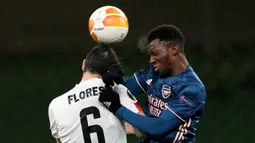 Striker Arsenal, Eddie Nketiah, berebut bola atas dengan gelandang Dundalk, Jordan Flores, pada laga lanjutan Liga Europa 2020/2021 di Aviva Stadium, Jumat (11/12/2020) dini hari WIB. Arsenal menang 4-2 atas Dundalk. (AFP/Paul Faith)