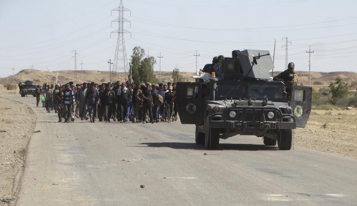 Pasukan tentara Irak mengawal puluhan warga yang melarikan diri setelah terjadi pertempuran antara pasukan Irak dan militas ISIS di kota Hit, provinsi Anbar, (5/4/2016). (REUTERS/Stringer)