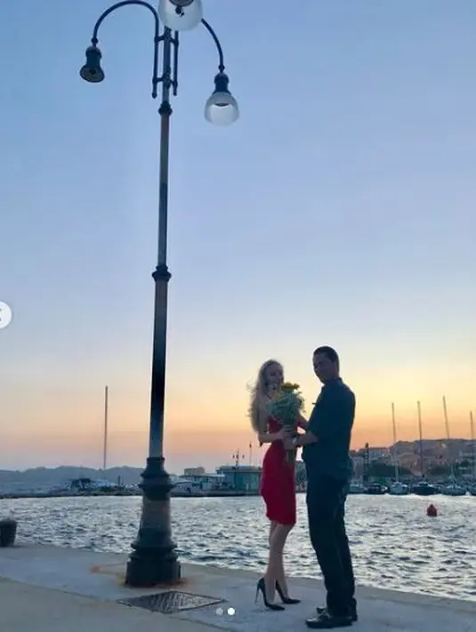 Romantisnya, Panji Adhikumoro melamar Varsha Strauss sebelum resmi menjadi istrinya di pinggir laut. Tak lupa buket bunga, menjadikan suasana semakin romantis. (Foto: Instagram/@varshaadhikumoro)