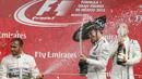Dua pebalap Mercedes saling semprotkan sampanye di podium juara F1 GP Meksiko di Sirkuit Autodromo Hermanos Rodriguez, Senin (2/11/2015) dini hari WIB. (EPA/Ulises Ruiz Basurto)