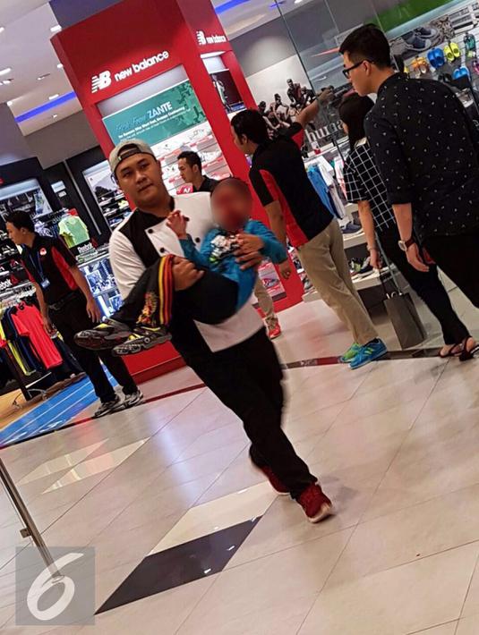 Seorang petugas restoran menggotong anak kecil korban akibat reruntuhan  di Mall AEON, BSD, Tangerang Selatan, Rabu (20/4/2016).Petir menyambar kaca mall tersebut. (Istimewa)