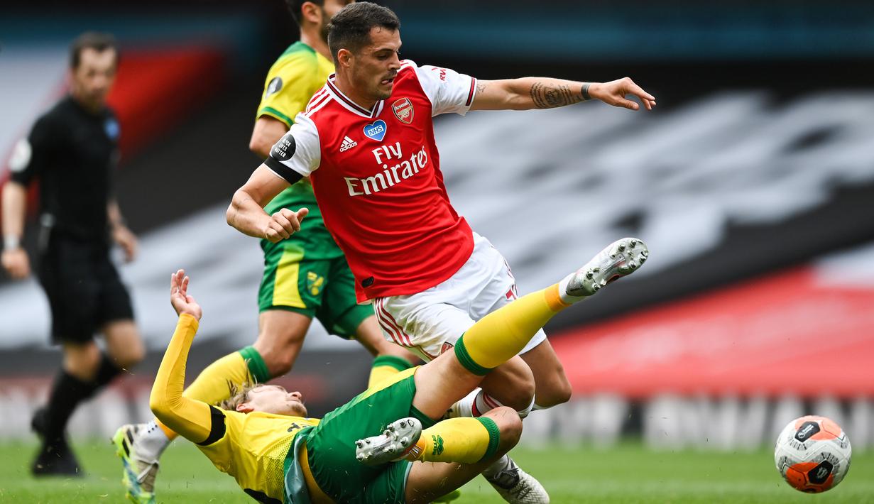 Gelandang Arsenal, Granit Xhaka, berebut bola dengan gelandang Norwich City, Tom Trybull, pada laga lanjutan Premier League pekan ke-32 di Emirates Stadium, Kamis (2/7/2020) dini hari WIB. Arsenal menang 4-0 atas Norwich City. (AFP/Shaun Botteril/pool)